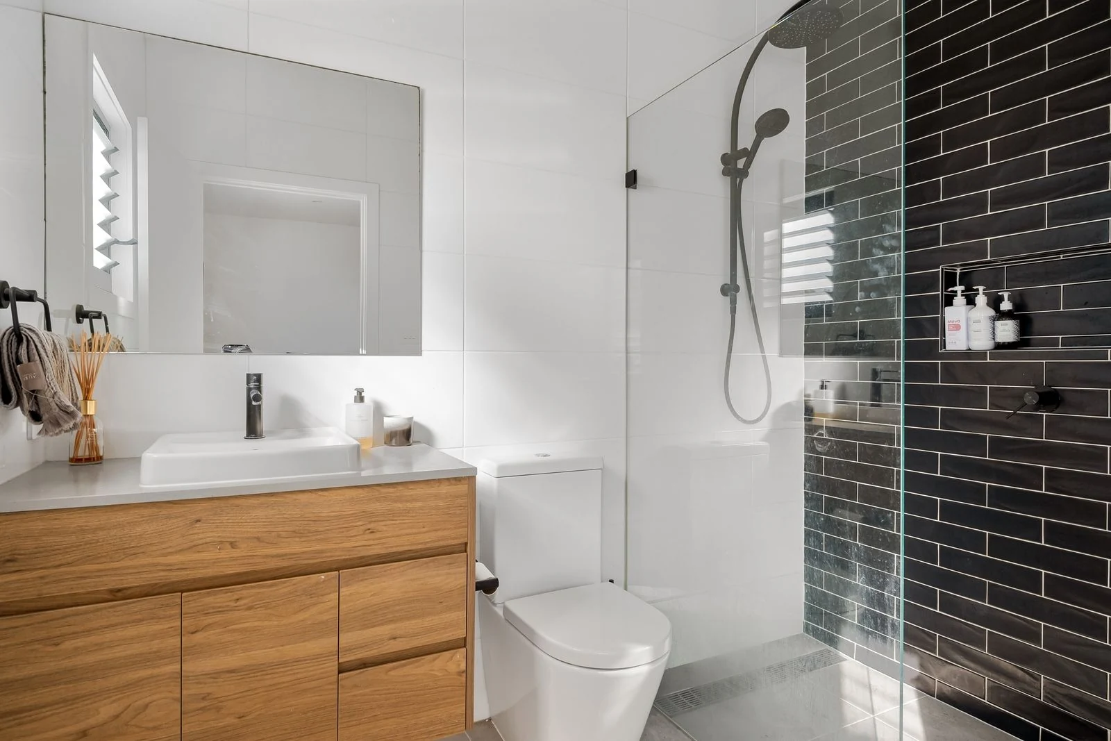 A contemporary bathroom featuring sleek black tiles, modern fixtures, and minimalist design