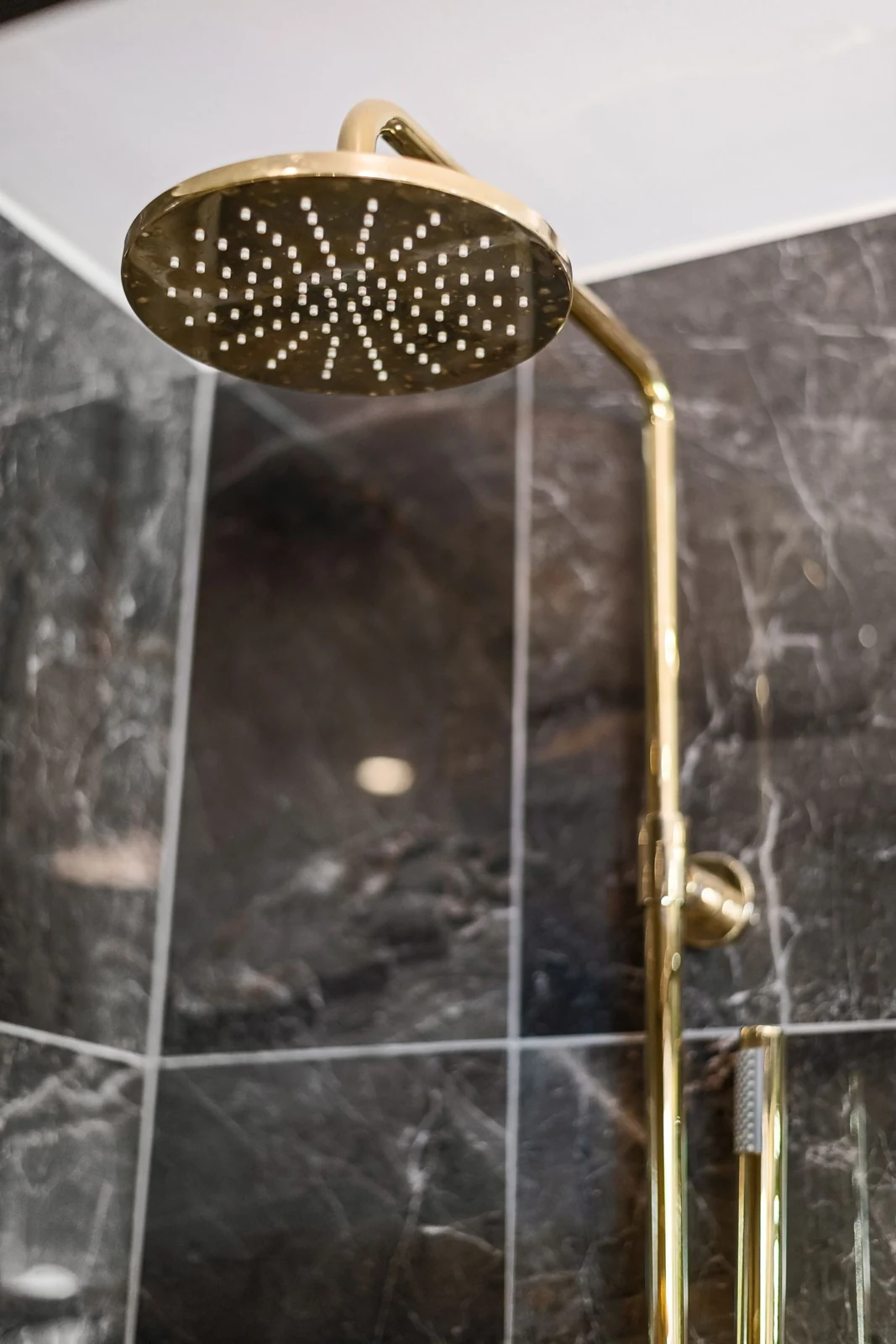 Overhead shower and tiled wall