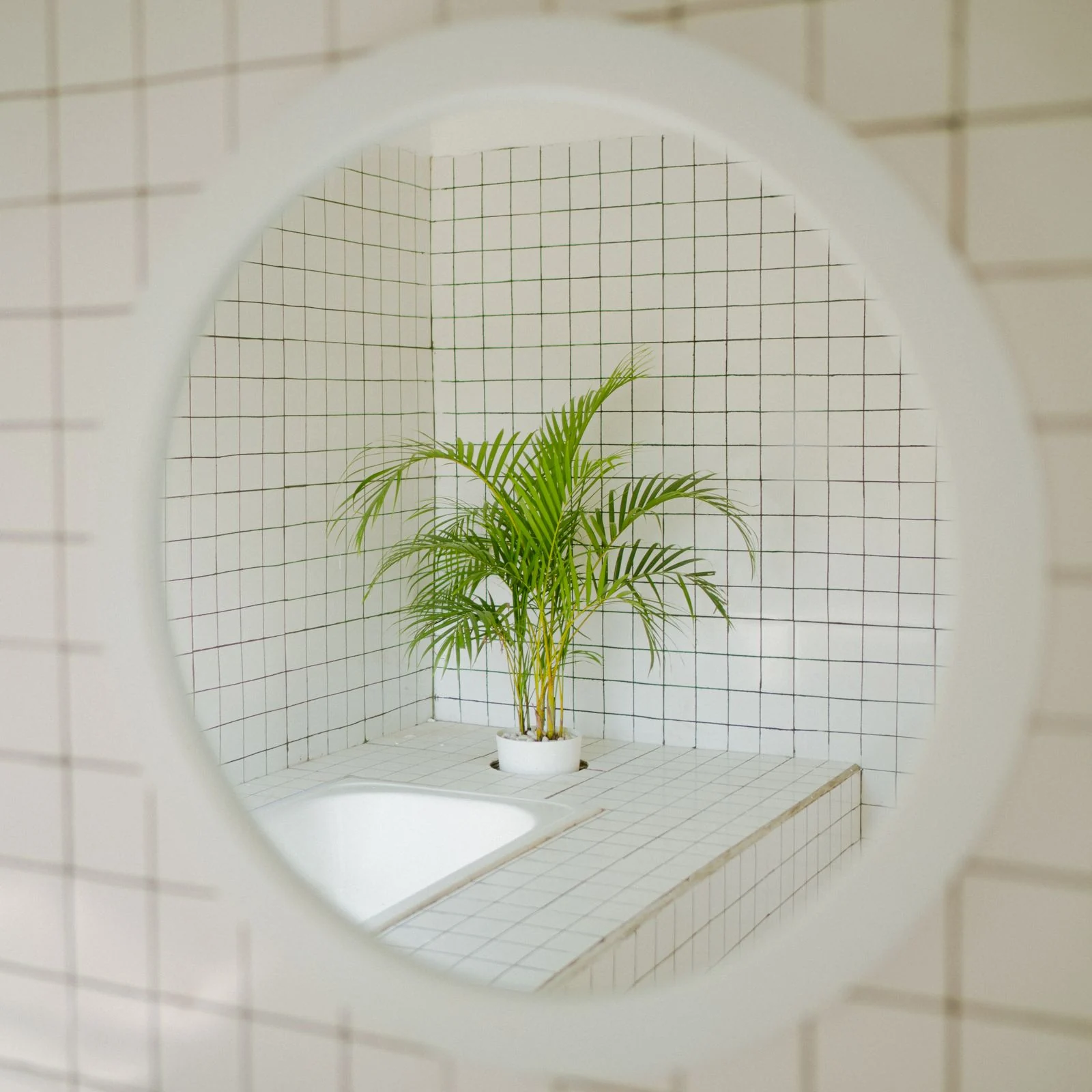 Round bathroom mirror above a basin