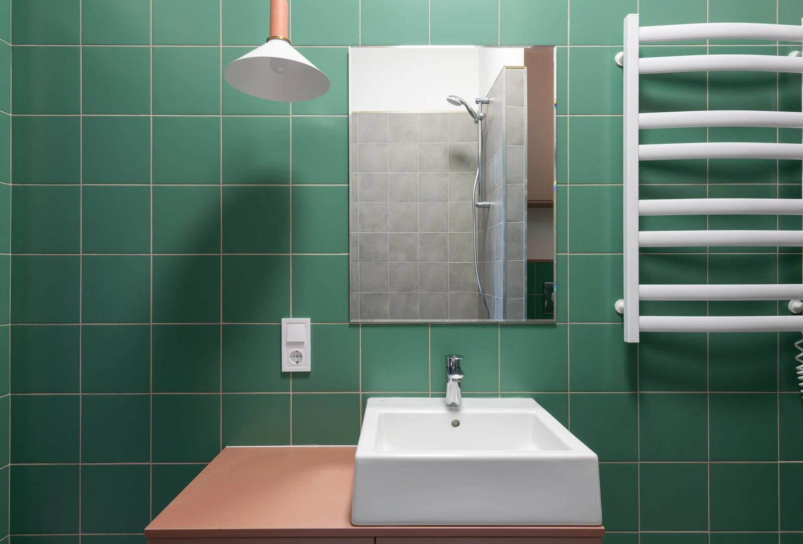 Bathroom basin against green wall tiles