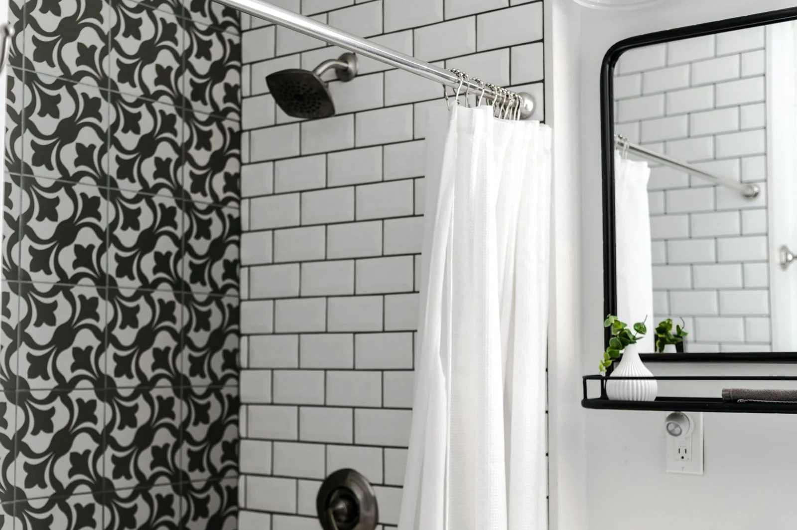 Contemporary bathroom featuring patterned and subway tiles with a minimalist mirror and white shower curtain